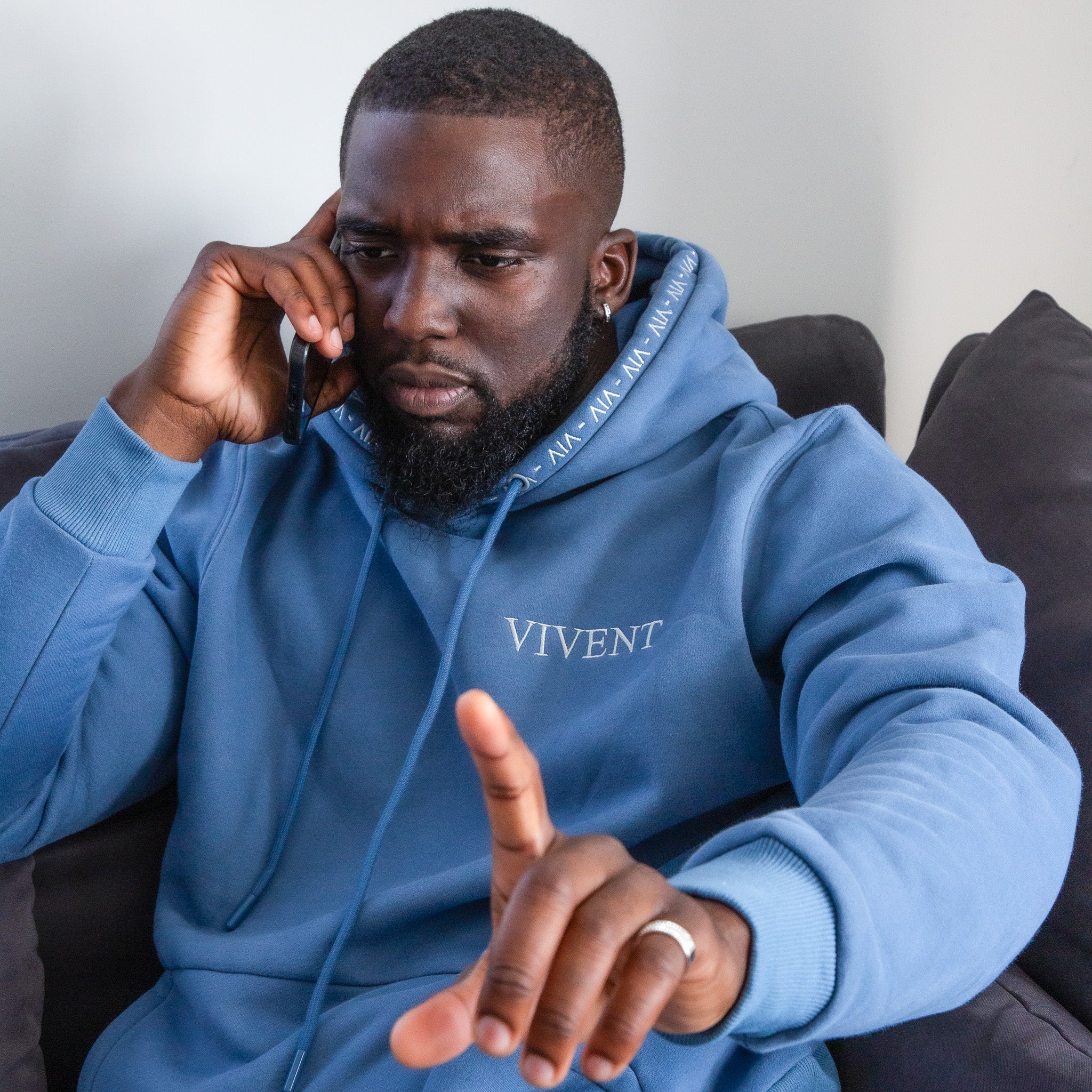 Man wearing VIVENT clothing while on the phone